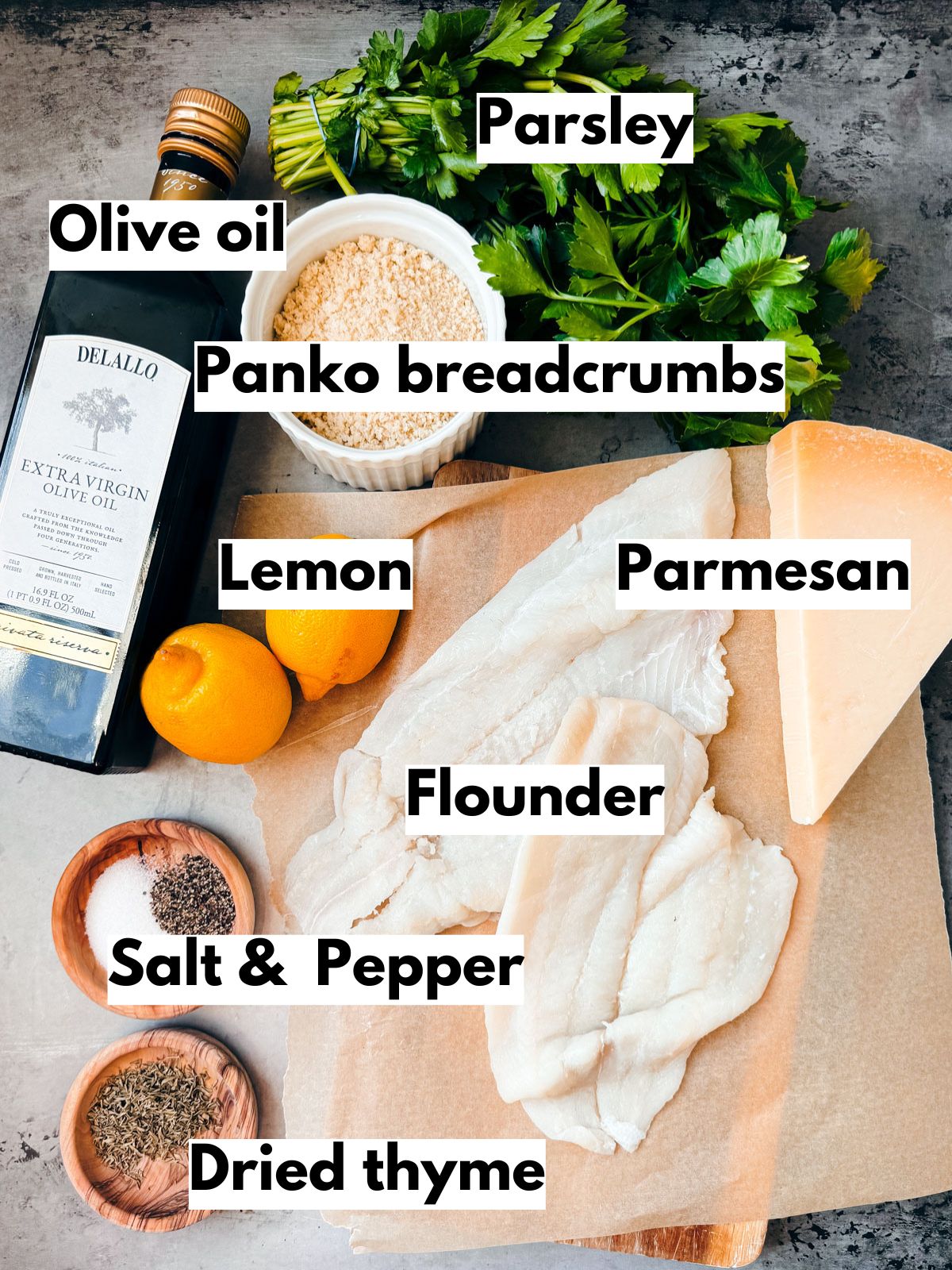 Ingredients for baked flounder au gratin on a dark stone background.