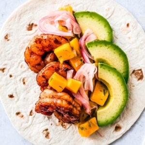 Flour tortilla topped with juicy shrimp, mango salsa, pickled onions, and avocado.