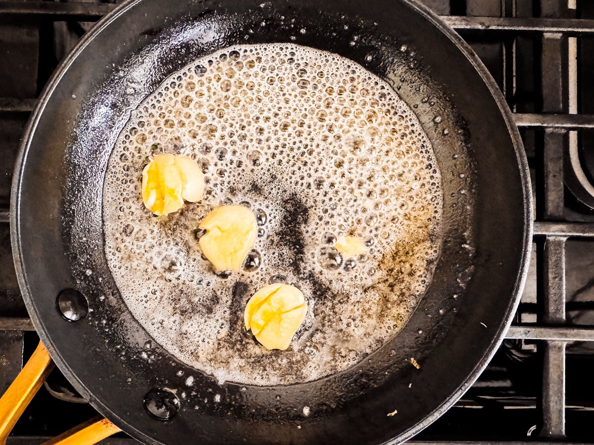 Butter melting and foaming in a pan.