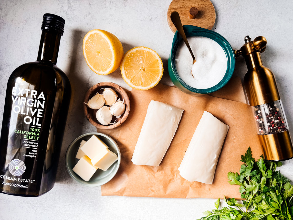 Ingredients for Chilean sea bass and garlic butter on a white background.