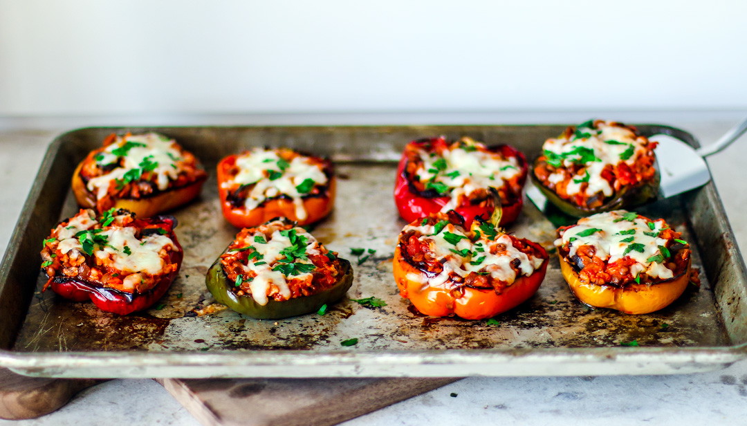 Cooked stuffed peppers on a baking sheet.