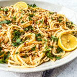 Spaghetti aglio e olio in a serving dish topped with bread crumbs.