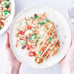 Hands holding up plate of Morrocan-spiced rockfish.
