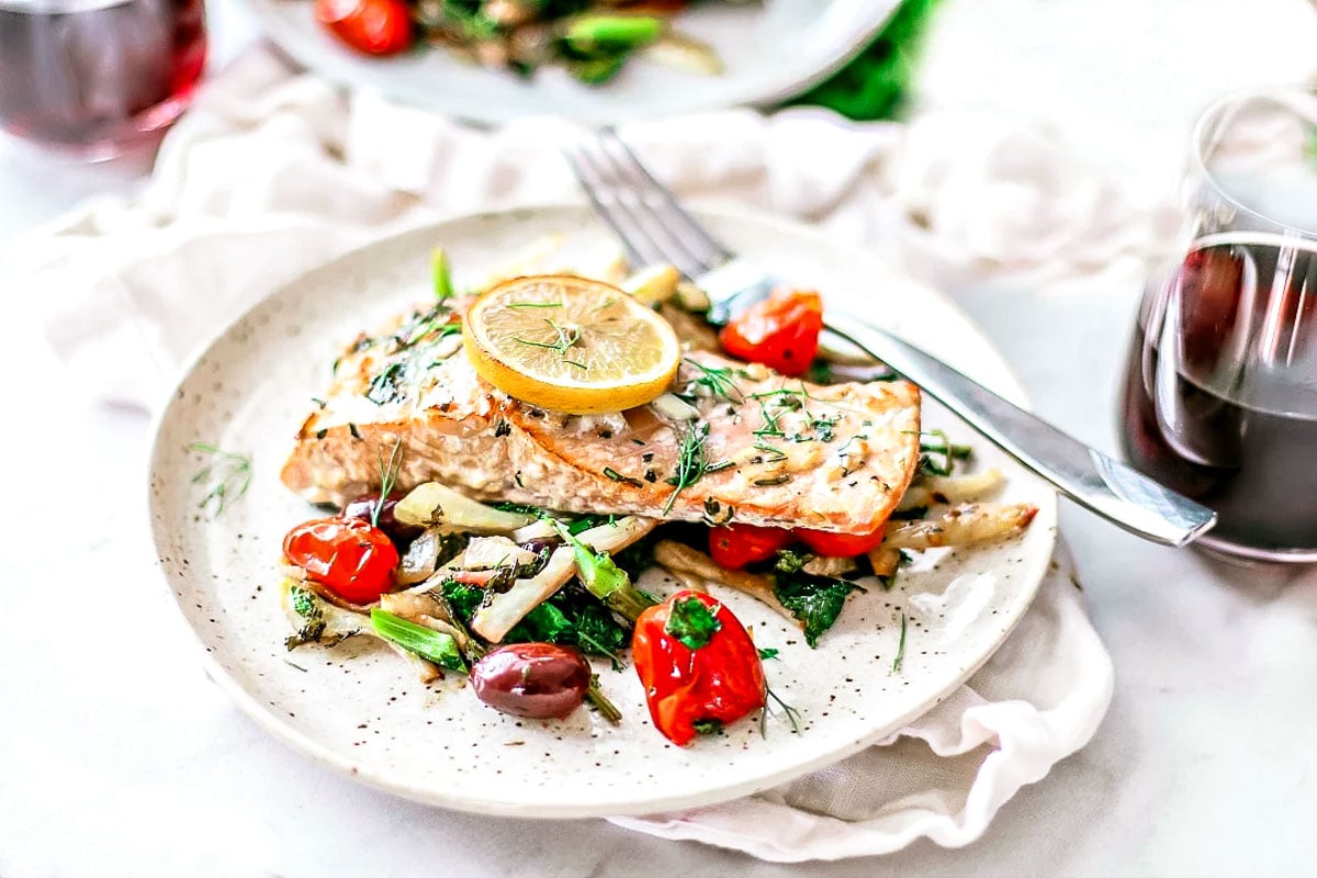 Cedar plank salmon over bed of veggies.