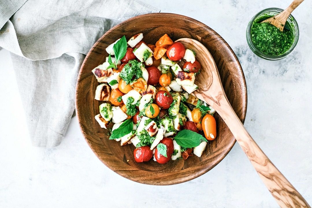 Grilled Halloumi and Burst Tomato Salad With Pesto in a bowl