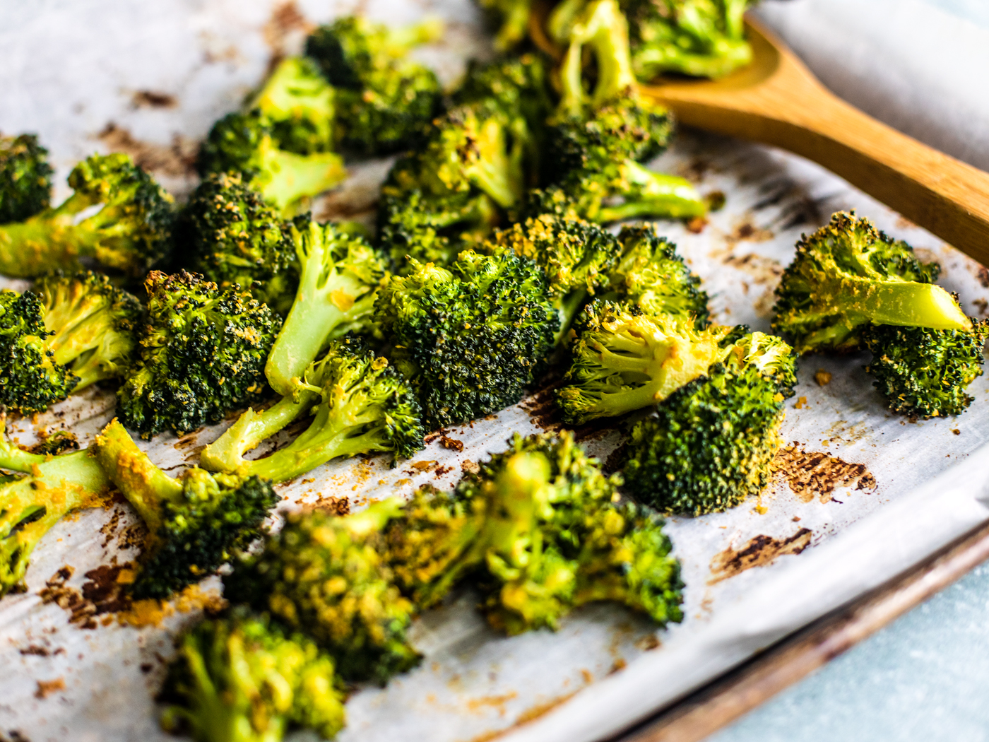 Side shot close up of roasted broccoli on sheet pan.
