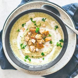 Bowl of cream of broccoli soup garnished with croutons.