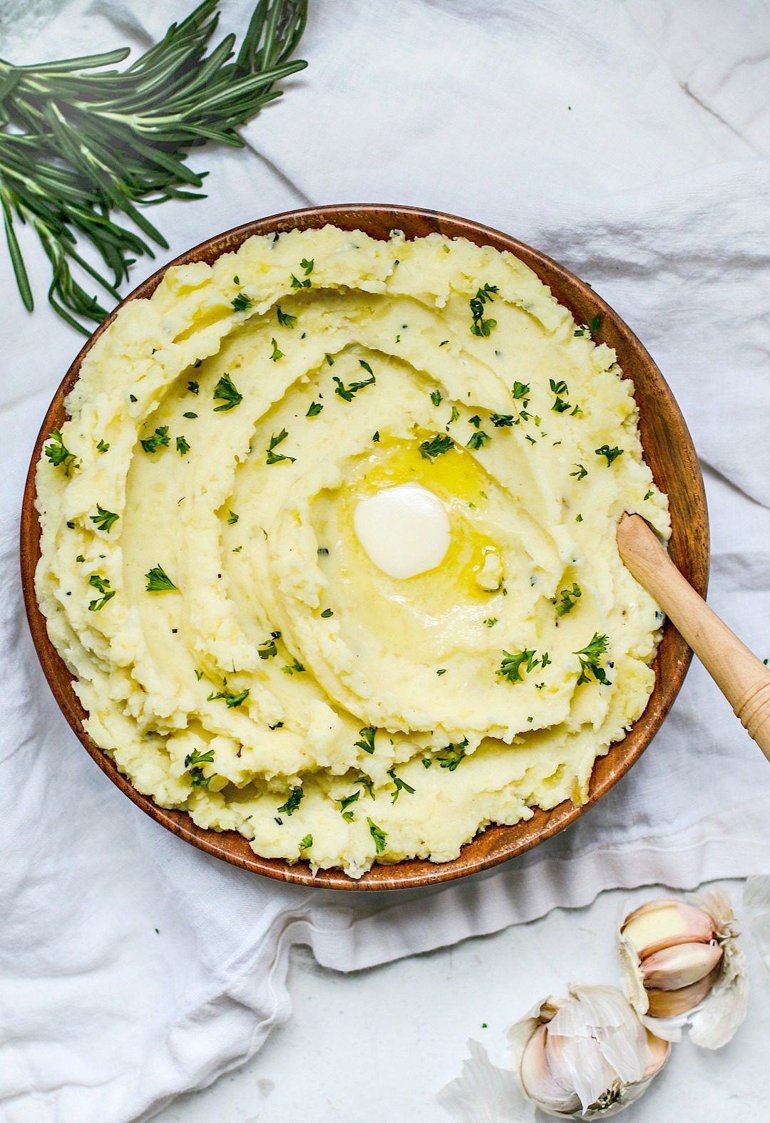 Big buttery bowl of mashed potatoes with roasted garlic and rosemary.