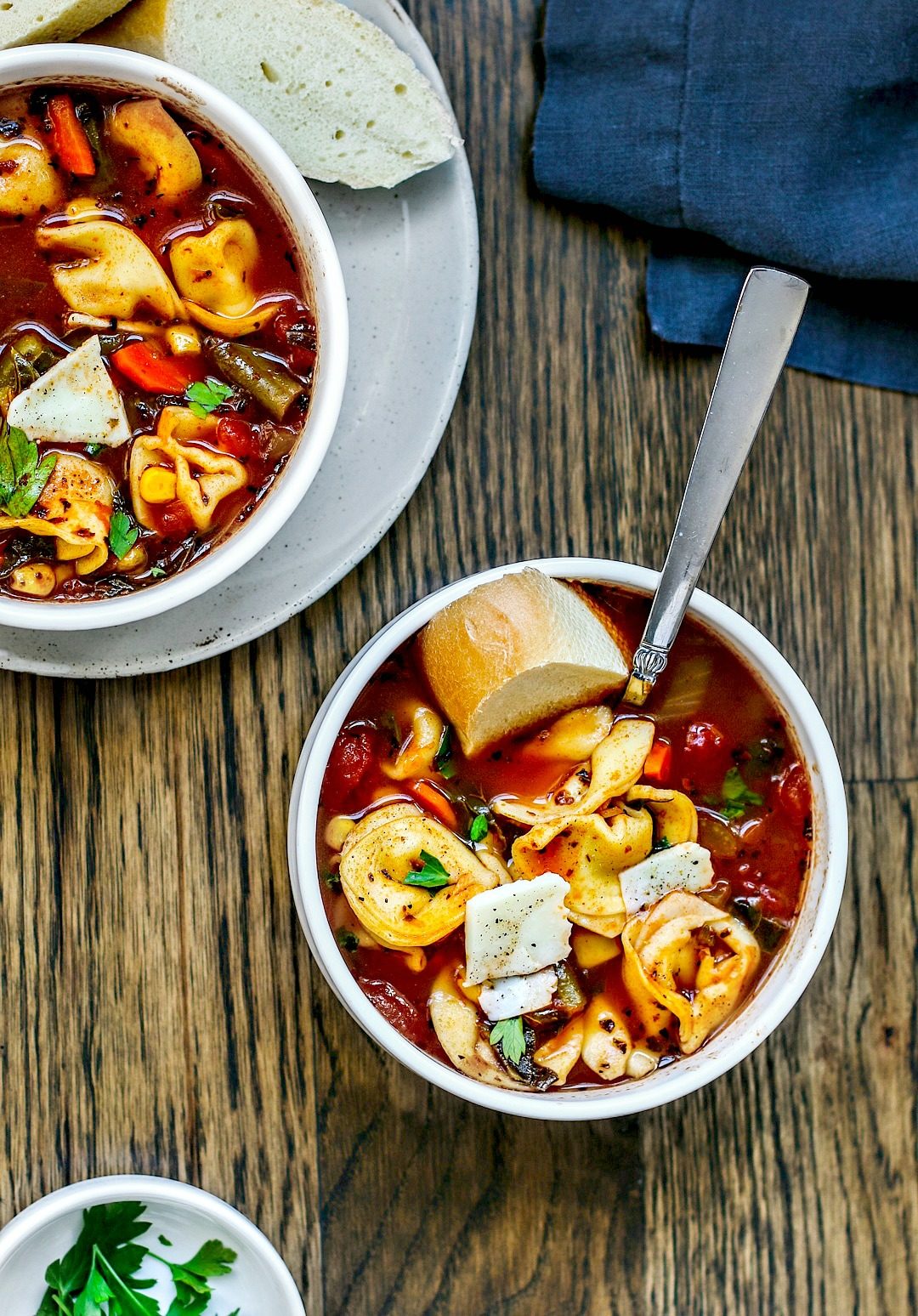 Two bowls of vegetable soup with cheese tortellinis.