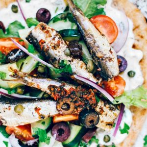 Pita topped with tzatziki, fresh veggies, and Mediterranean sardines.
