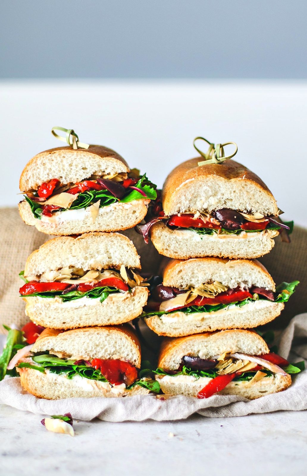 Italian Antipasto Sandwiches cut in halves and stacked.
