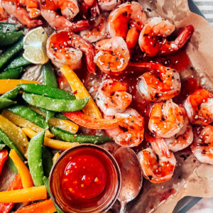 Veggies and shrimp on a sheet pan smothered with sweet Thai chili sauce.