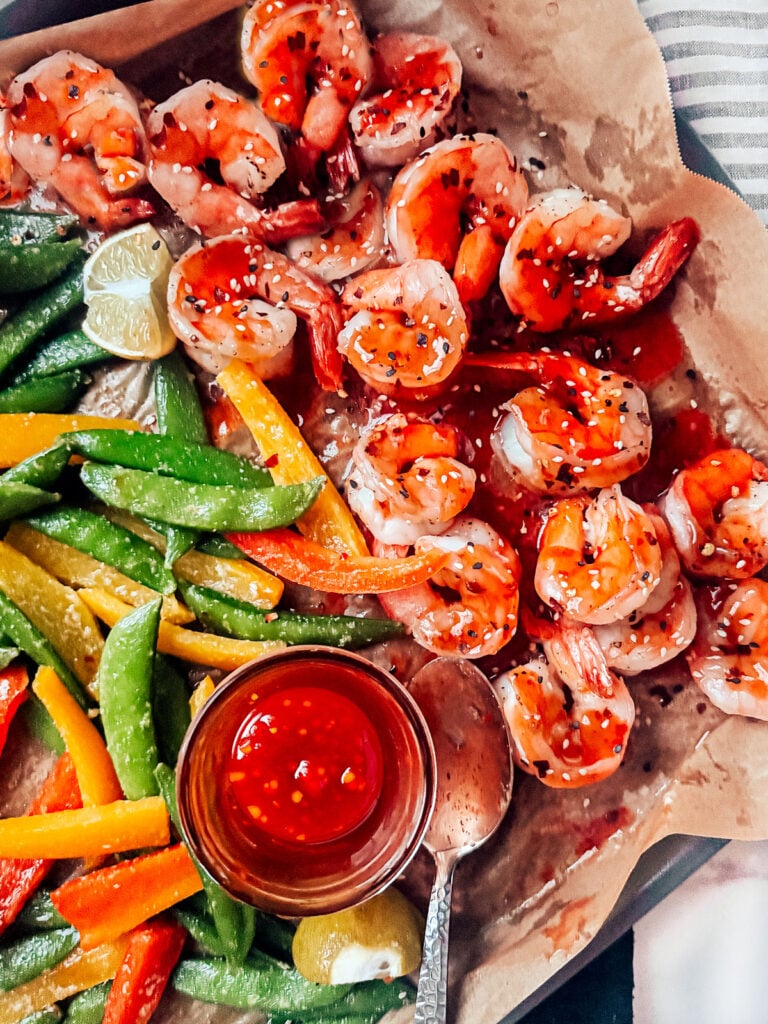 Veggies and shrimp on a sheet pan smothered with sweet Thai chili sauce.