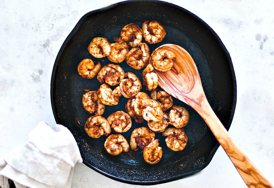 Blackened shrimp in cast iron skillet.