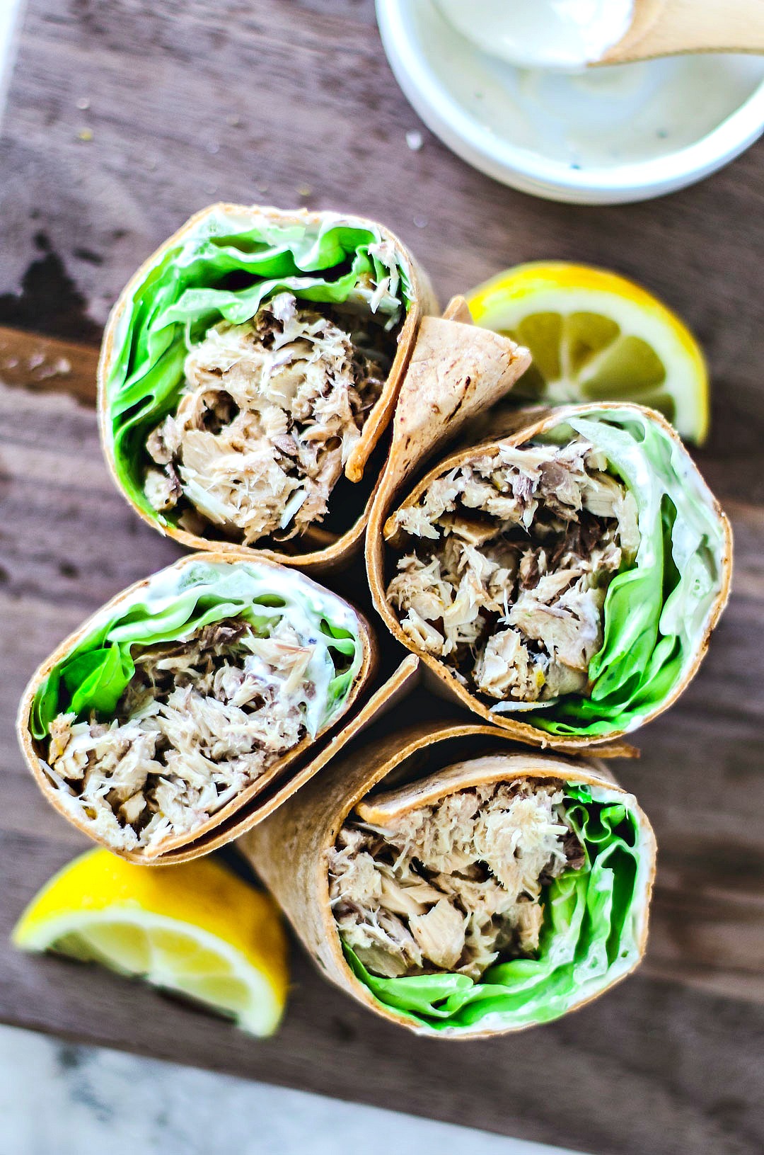 Close up of Lemon Mackerel Caesar Wraps standing upright on plank.