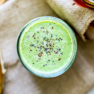 Close up of bright green smoothie with chia seeds sprinkled on top.