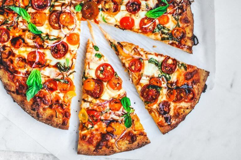 Bruschetta pizza slices pulled away from pizza.