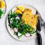 Plated chicken cutlet with bright arugula salad.
