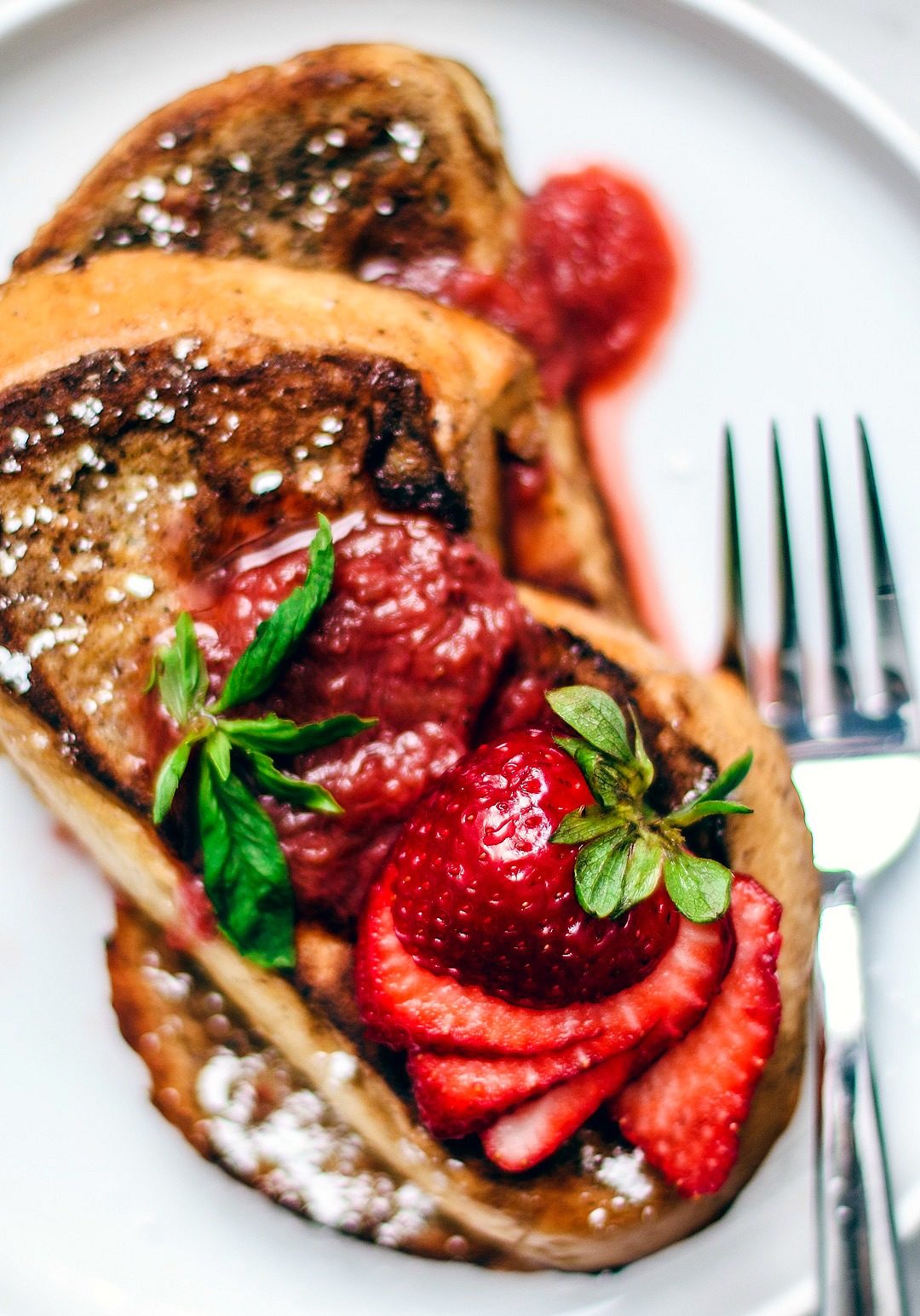 Close up of fresh strawberries fanned over French toast.