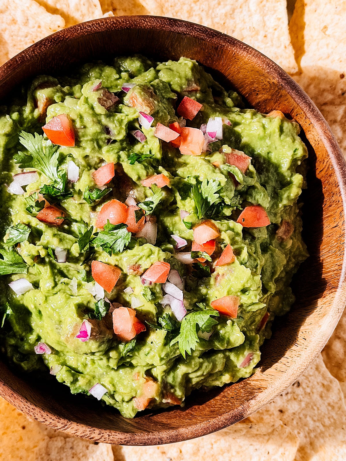 Close up of serving bowl of chunky guacamole. 