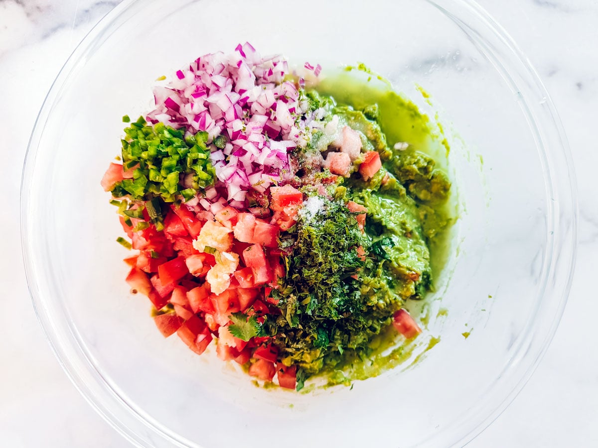 Mashed avocado topped with chopped tomatoes, onions, jalapeño, and cilantro.