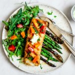 Plate of Grilled Mahi Mahi with bright salad and veggies.