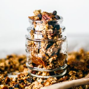 Homemade granola in a jar and scattered over a tray.