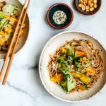 Bowls of sesame noodles with cucumber and mango salad.