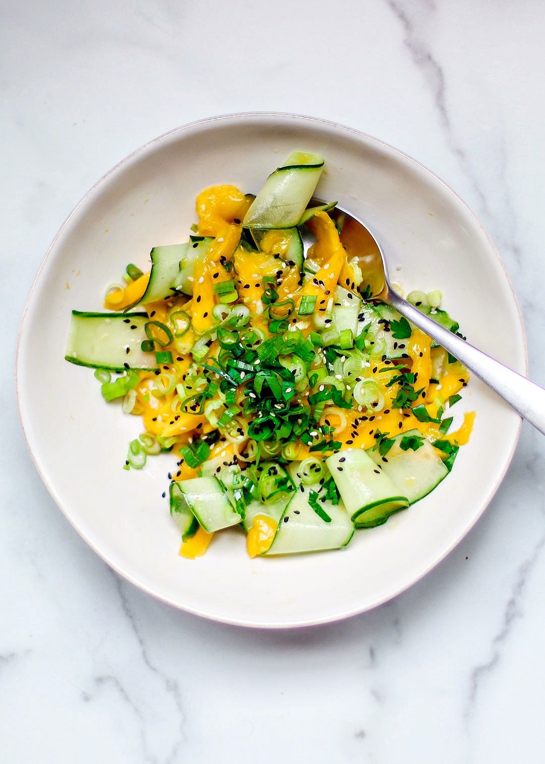 Bowl of shaved cucumber and mango salad.