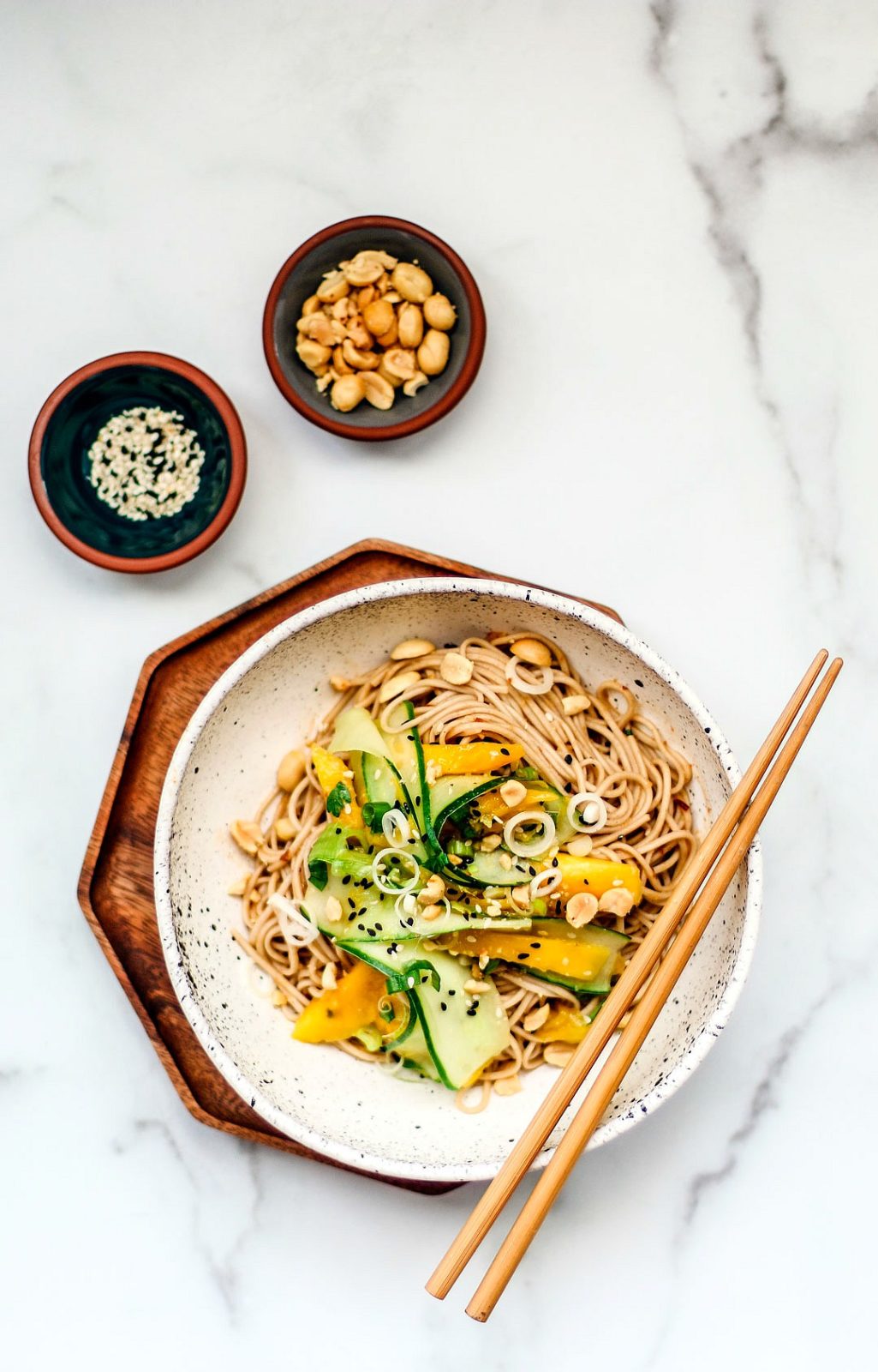 Bowl of sesame noodles with cucumber and mango salad.