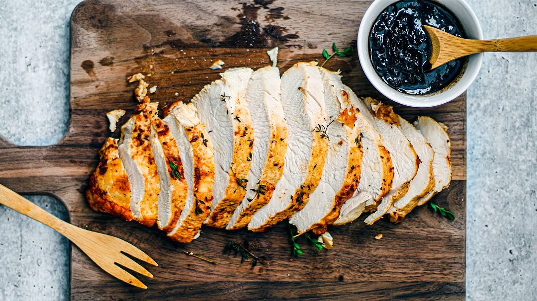 Roast turkey sliced on a wooden cutting board.