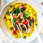 Bowl of golden rice, mackerel, tomatoes, and scallions.