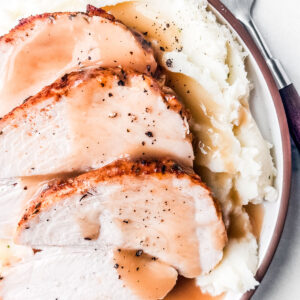 Oven roasted turkey on mashed potatoes with gravy.