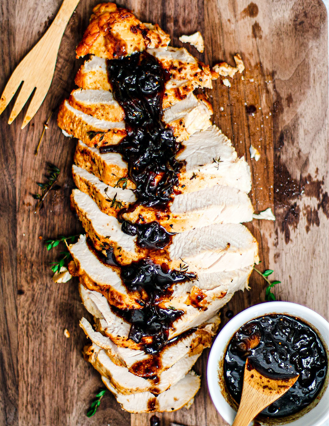 Overhead shot of roast turkey sliced on cutting board and topped with cranberry balsamic glaze.