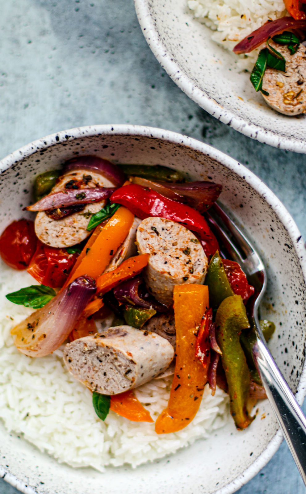 Close up of bowl of rice with sausage and peppers.