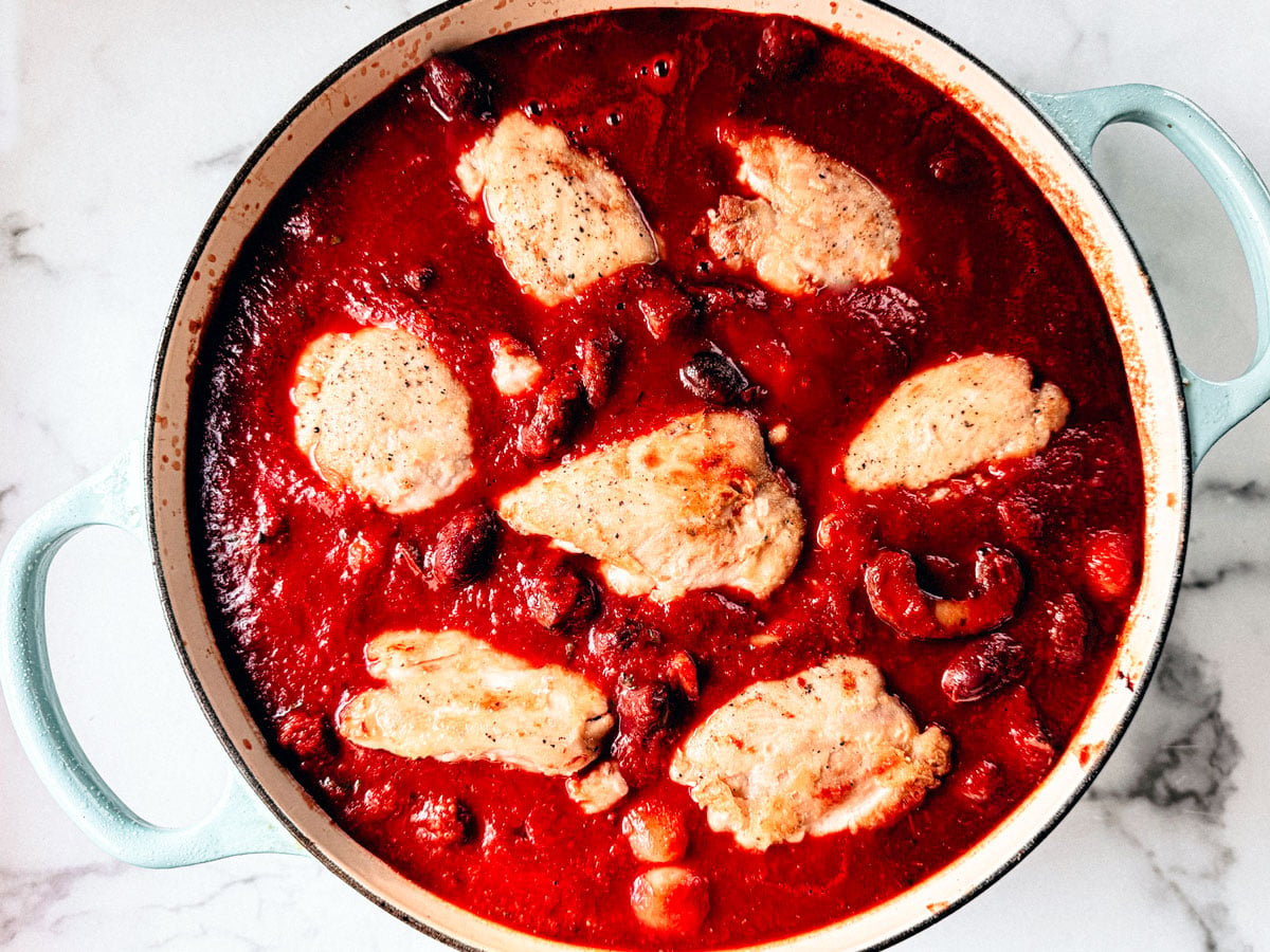 Browned chicken thighs nestled in tomato sauce.