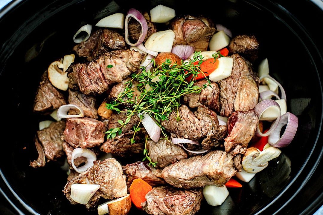Close up of beef and veggies in slow cooker.