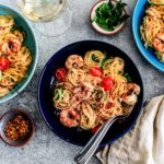 Three plates of shrimp scampi spread out.