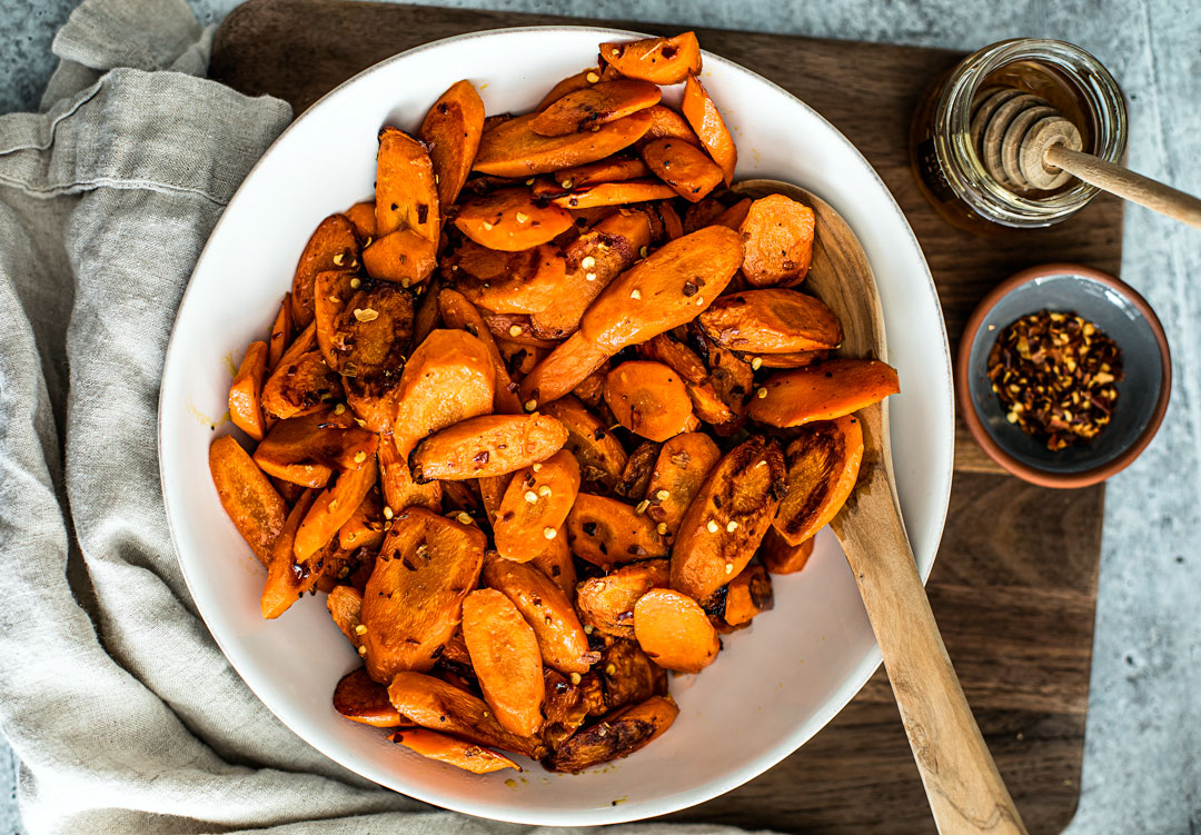 Bowl of roasted carrots tossed in hot honey.