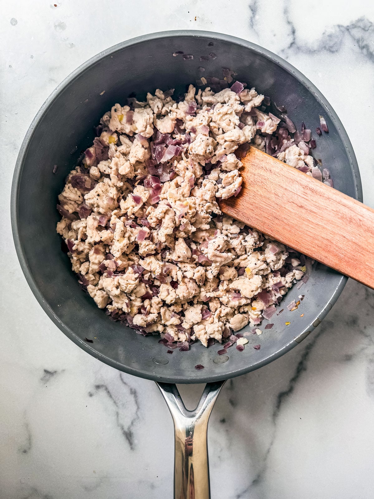 Grund turkey and fried onions in pan.