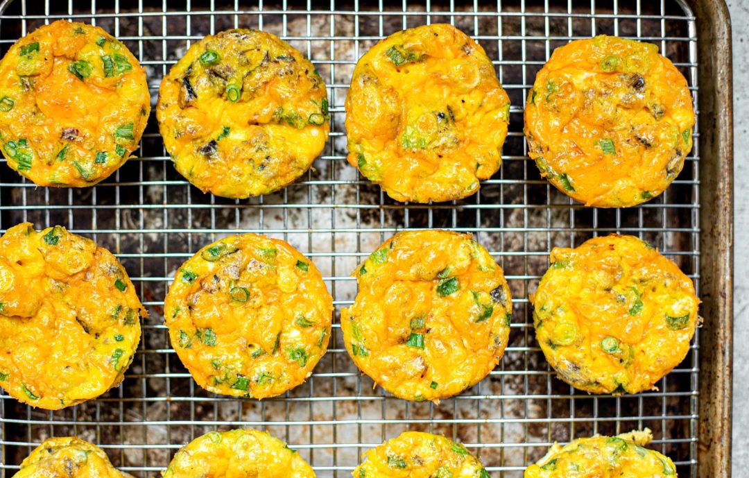Egg muffins lined up on a cooling rack.