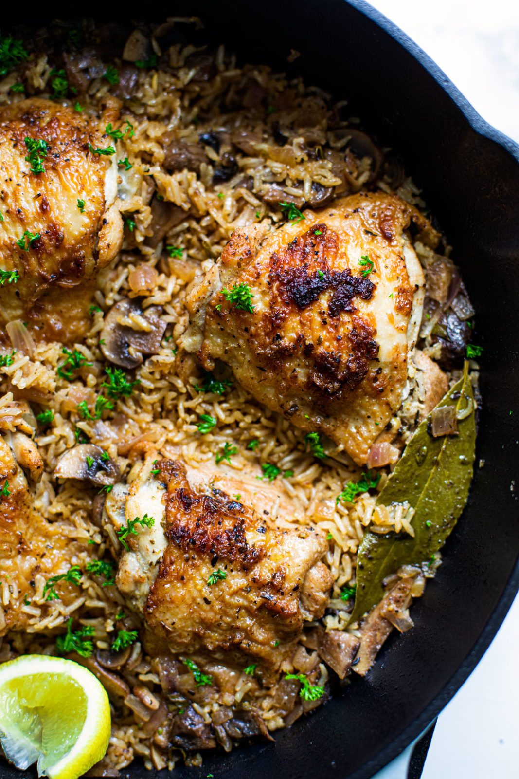 Pan full of rice and crispy herb and garlic chicken thighs.