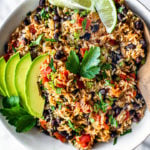 Close up of bowl of Instant Pot Mexican Rice with fresh parsley and sliced avocado on top.