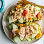 Toast topped with smashed avocado, ribboned cucumber, tomatoes, and flaked tuna.