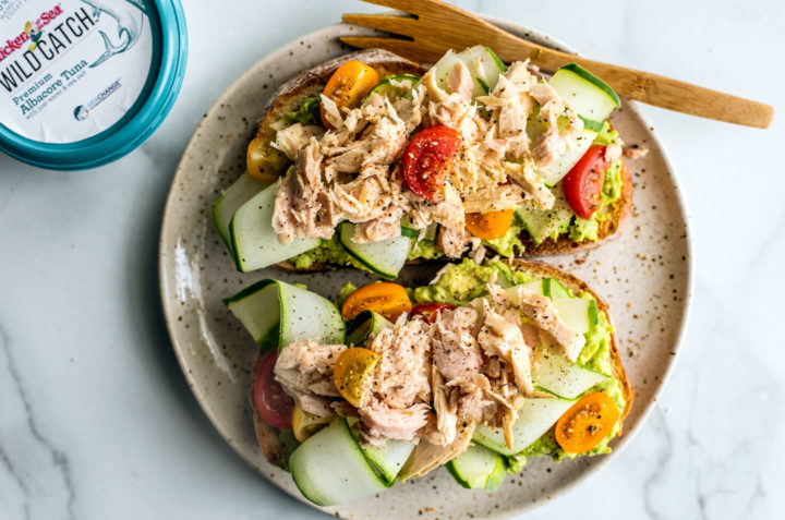 Toast topped with smashed avocado, ribboned cucumber, tomatoes, and flaked tuna.
