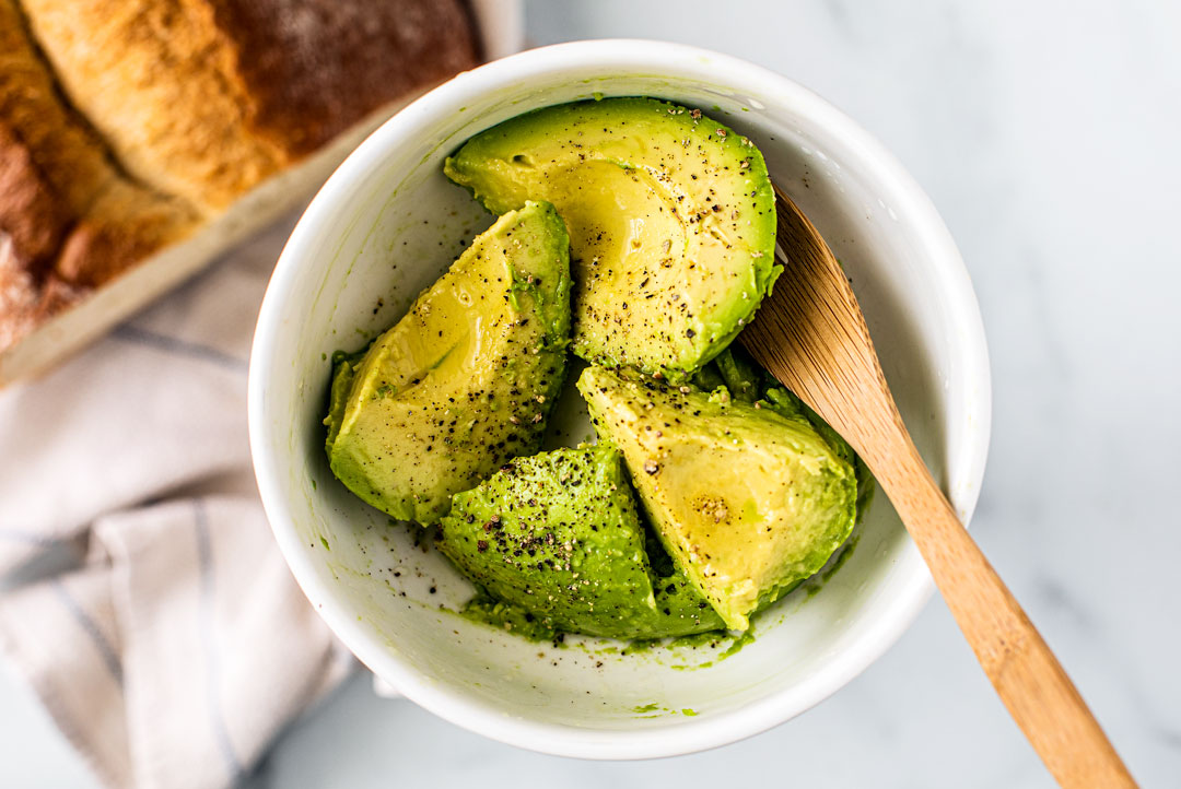 Close up of bowl of chopped avocado.