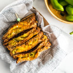 Hatch chile grilled cheese in newspaper next to a bowl of fresh Hatch chiles.