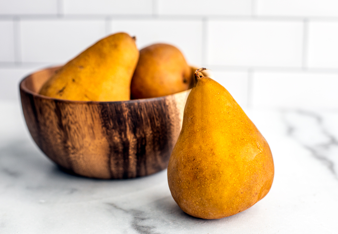 Bowl of Bosc pears on a counter top.