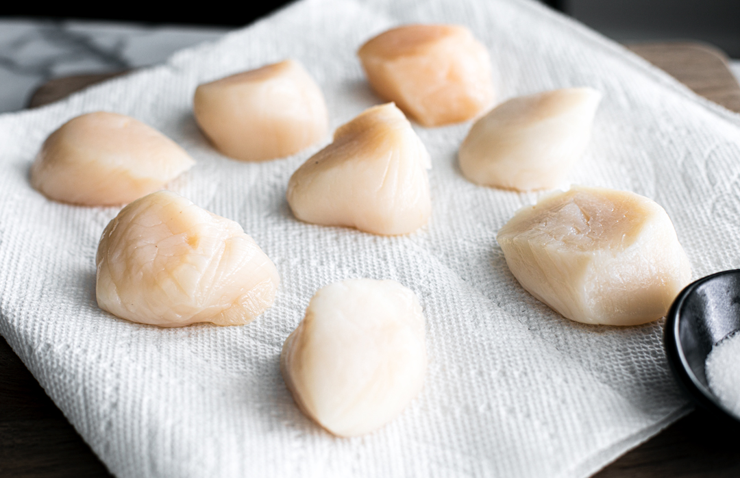 Raw scallops on a paper towel.