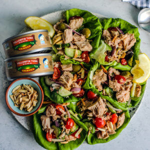 Plate of lettuce cups next to two cans of Genova tuna.